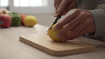 Cutting lemon fruit into slices on a wood cutting board with a knife video