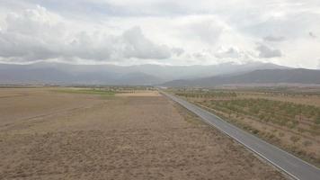 Vue aérienne 4k de la route goudronnée droite à travers guadix, grenade. en arrière-plan la sierra nevada video