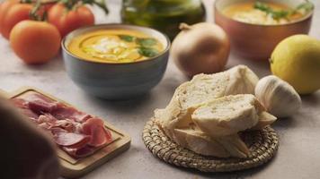 Brot und Schinken auf dem Tisch servieren, neben dem Salmorejo oder Gazpacho video