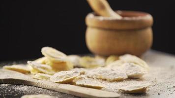 Tasty raw ravioli with flour and basil on wood table video