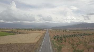 4k luchtfoto van rechte geasfalteerde weg door guadix, granada. op de achtergrond sierra nevada video