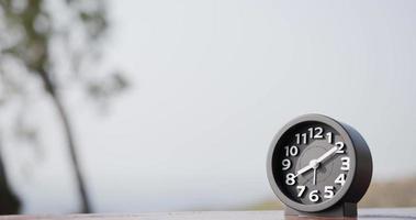 Time lapse, The black alarm clock shows the running of time. In good weather. Outdoors background. video