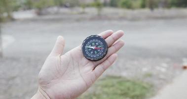 Nahaufnahme, schwarzer Kompass in einer transparenten Hand. zeigt die Richtung nach außen. video