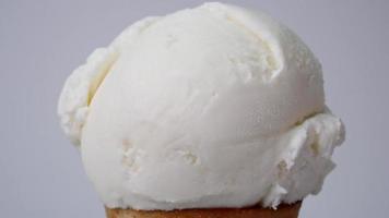 fusione del gelato al tè alla vaniglia su un cono. scorre lentamente dopo che il gelato si è sciolto. sullo sfondo bianco. video
