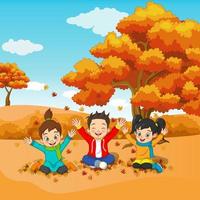 niños felices de dibujos animados jugando en el fondo de otoño vector