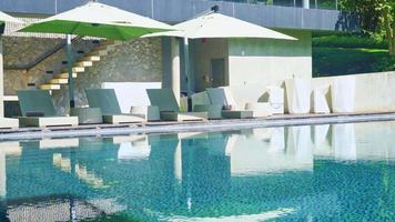 bed pool with umbrella around swimming pool - Holidays and vacations concept video