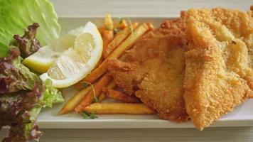 fish and chips - fried fish fillet with potatoes chips and lemon on white plate video