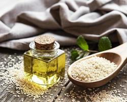 Sesame oil and seeds on a rustic table. photo