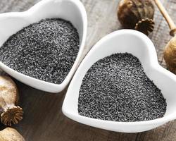 Poppy seeds in heart shaped  bowls photo