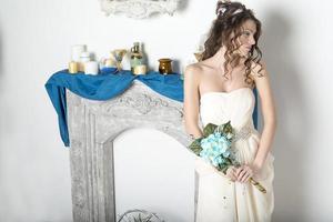 Girl in white near the decorative fireplace. photo