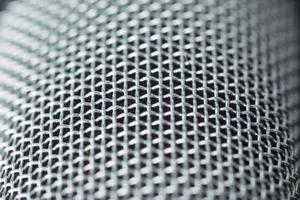 Steel grille background. Close-up shot of microphone. photo