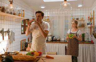 pareja joven se prepara para cocinar un desayuno en la cocina con una sonrisa divertida y felicidad foto