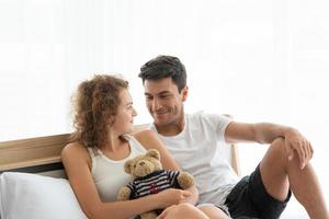 Happy couples relaxing in the white bedroom Of the apartment photo