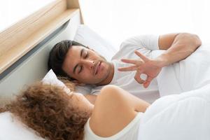 parejas felices descansando en el dormitorio blanco del apartamento foto