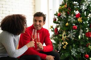 parejas en la sala de estar durante feliz navidad y próspero año nuevo