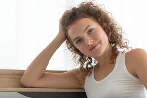 Woman relaxing in the white bedroom of the apartment photo