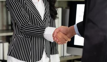 Businesswoman Shake Hands With Young Businessman After Signing Contract in Office
