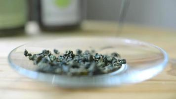 Tea leaves and flowers poured on a saucer - the art of beautiful tea video