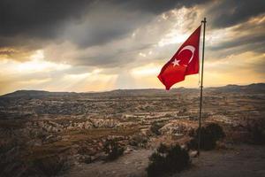 National Turkey symbol - turkish flag on post on hill top over Cappadocia valleys with dramatic copy space cloudscape photo