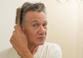 Mature Man Brushing an Combing his Hair photo