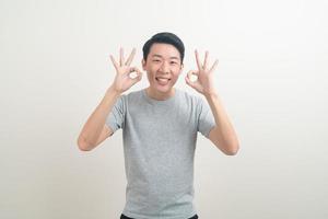 young Asian man thumbs up or ok hand sign photo