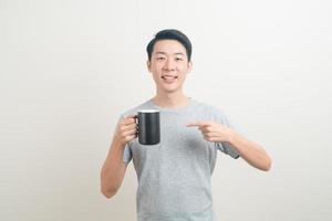 young Asian man holding coffee cup photo