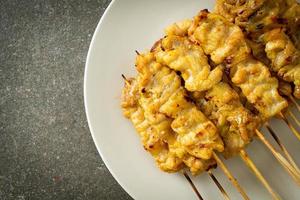 Pork satay with peanut sauce pickles which are cucumber slices and onions in vinegar photo