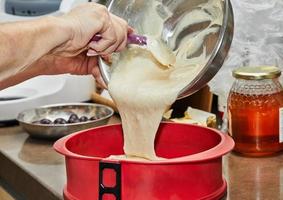 Cook puts the dough into a silicone cake pan photo