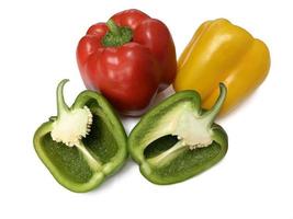 verduras frescas tres pimientos dulces. tres pimientos rojos, verdes y amarillos dulces aislados sobre fondo blanco. medio papper dulce. foto
