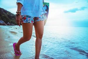 naturaleza de viaje de mujer asiática. viajar relajarse. caminando en la playa. en el verano foto