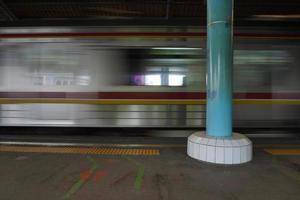 standing on the station platform with the blur background of the moving train photo