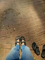 view of a man wearing sandals on a cement floor background photo