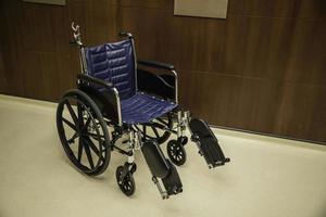 Silla de ruedas vacía estacionada en el pasillo del hospital esperanza