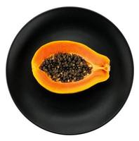 papaya en plato blanco, fondo negro. foto