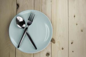 Plate and cutlery on wooden table photo