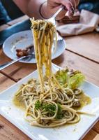 Spaghetti sauce, chopped spices and fresh basil on wooden table photo