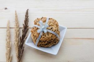 Place the cookies with a ribbon tied on a wooden floor. photo