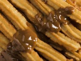 close up fried churros with melted chocolate photo