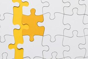 high angle view yellow puzzle piece arranged with white pieces photo
