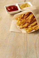 close up french fries with wooden background photo