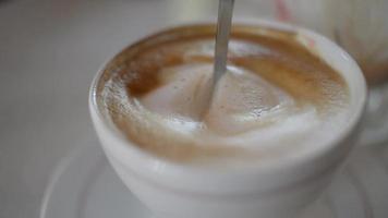 Stirring the milk in a cup of coffee video