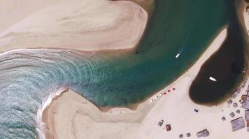 Imágenes aéreas de un dron volando sobre un río y un barco navegando lentamente por el agua