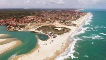 imagens aéreas de drones de uma praia paradisíaca de águas azul-turquesa e um pequeno vilarejo
