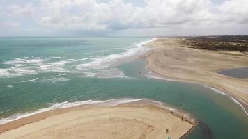 Panoramic aerial view of the beach with a small village and people having fun on the sand video