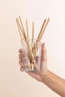 close up hand holding glass with straws photo
