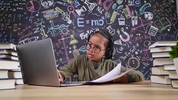 garota asiática séria, verificando a lição de casa e estudando on-line no laptop com microfone sem fio na sala de trabalho em casa. colocando o laptop na mesa e estudando on-line pelo conceito de laptop
