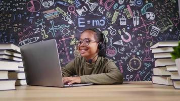 chica asiática escribiendo en la computadora portátil y usando un micrófono inalámbrico en la sala de estudio en casa. Poner la computadora portátil en la mesa y estudiar en línea por concepto de computadora portátil video