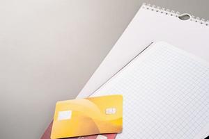 Vista de ángulo alto de calendario en blanco, cuaderno y tarjetas de crédito sobre fondo gris claro