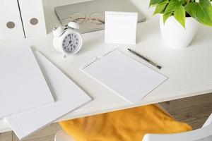 High angle view of desk arrangement with two blank calendars for mock up, magazines and stationery photo