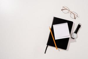 Minimal style black notebook and pens top view on green background, palm tree shadow overlay photo